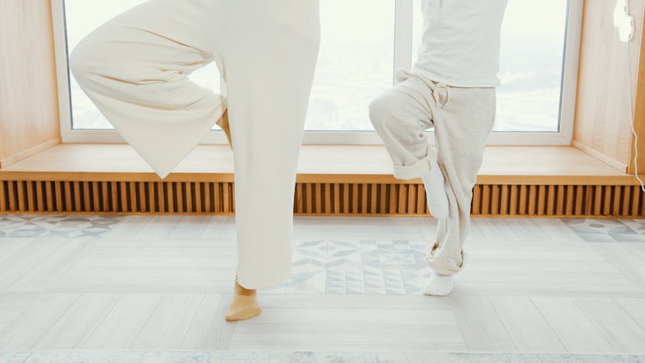 Woman practicing yoga on a mat at home near a large window, enjoying a moment of calm.